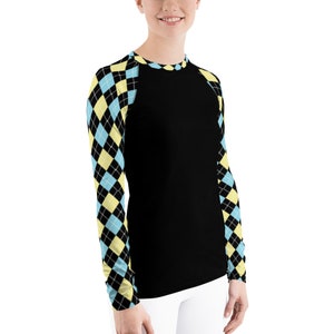May include: Black long-sleeve shirt with a yellow and blue diamond pattern on the sleeves. The shirt has a crew neck and a raglan sleeve design.