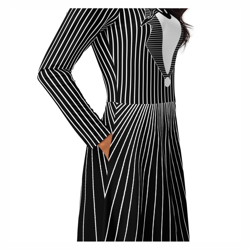 K&ouml;nnte beinhalten: Schwarz-wei&szlig; gestreiftes Kleid mit einem wei&szlig;en Fliege und Kragen Design. Das Kleid hat lange &Auml;rmel und einen ausgestellten Rock.