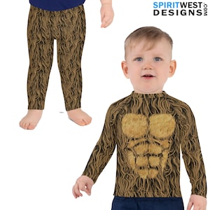 Op de afbeelding: Een bruin en beige longsleeve shirt met een harige textuur en een gespierd borstontwerp. Het shirt wordt gedragen door een jong kind. De afbeelding toont ook een bruin en beige legging met een harige textuur.