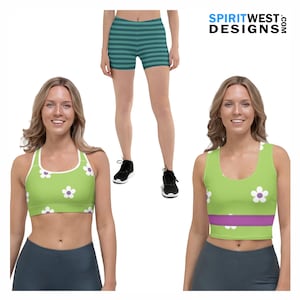 May include: Two women wearing athletic wear. One is wearing a green and white sports bra with a flower pattern and dark grey shorts. The other is wearing a green and purple tank top with a flower pattern and dark grey shorts. Both women are wearing black sneakers.