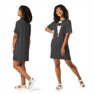 K&ouml;nnte beinhalten: Schwarz-wei&szlig; gestreiftes T-Shirt-Kleid mit einem Aufdruck von Jack Skellington aus Nightmare Before Christmas, der einen Smoking tr&auml;gt. Das Kleid hat kurze &Auml;rmel und eine lockere Passform.