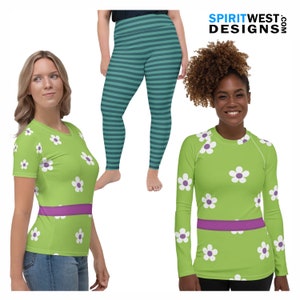 May include: Two women wearing green and purple shirts with white flower patterns. The shirts have a purple band around the waist. One woman is wearing blue jeans and the other is wearing teal and white striped leggings.