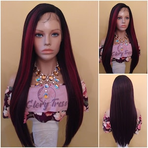 May include: A long, straight synthetic wig with dark brown and burgundy highlights. The wig is styled with a side part and falls to the shoulders. The wig is worn by a mannequin with a floral patterned top.
