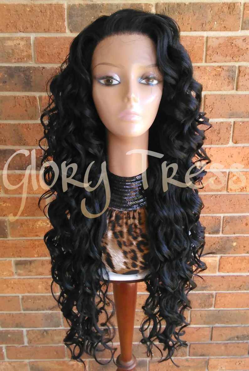 May include: A long, black, curly wig with a lace front. The wig is styled in loose curls and is worn on a mannequin head.