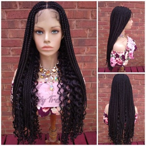 May include: A black braided wig with long, curly ends. The wig is made with a lace front and is styled in a box braid pattern.