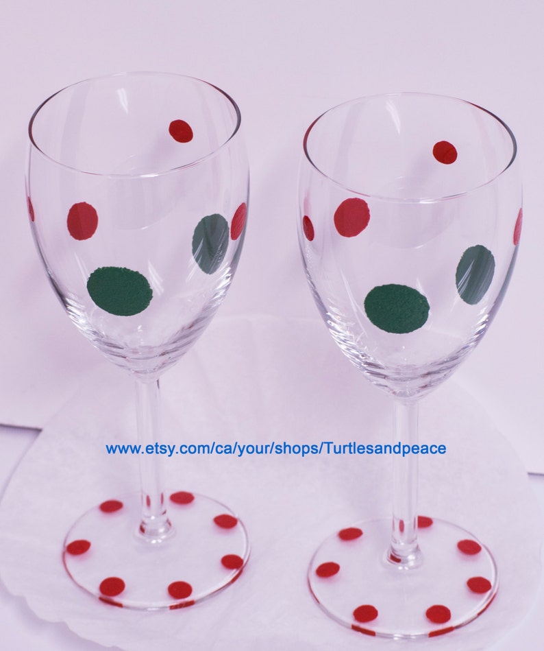 Puede incluir: Dos copas de vino de vidrio transparente con lunares rojos y verdes. Las copas est&aacute;n sobre una superficie blanca con la direcci&oacute;n del sitio web www.etsy.com/ca/your/shops/Turtlesandpeace.