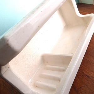 May include: White ceramic bathroom shelf with a built-in soap dish. The shelf has a crackled glaze finish.