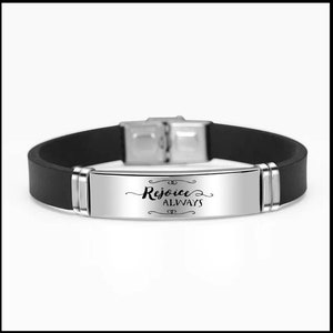May include: A black silicone bracelet with a silver metal plate engraved with the words "Rejoice Always" in a decorative font.