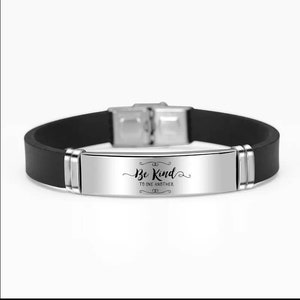 May include: A black silicone bracelet with a silver metal band that reads "Be Kind to One Another".