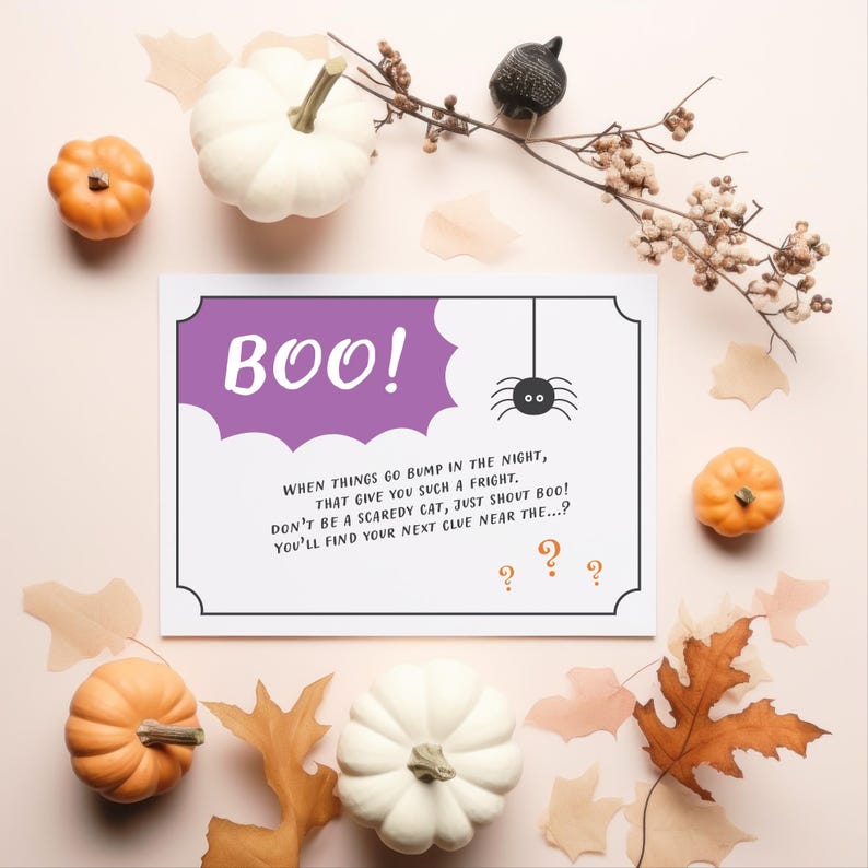 Puede incluir: Una composici&oacute;n tem&aacute;tica de Halloween con una tarjeta con la palabra "BOO!" y una ilustraci&oacute;n de ara&ntilde;a. La tarjeta est&aacute; rodeada de calabazas blancas y naranjas, hojas de oto&ntilde;o y una rama decorativa. El texto de la tarjeta dice "Cuando las cosas se topan en la noche..."