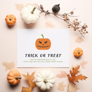 Puede incluir: Una composici&oacute;n tem&aacute;tica de Halloween con una tarjeta blanca que muestra una calabaza naranja y el texto "TRICK OR TREAT". La tarjeta est&aacute; rodeada de calabazas, hojas de oto&ntilde;o y ramas, todo sobre un fondo rosa claro.