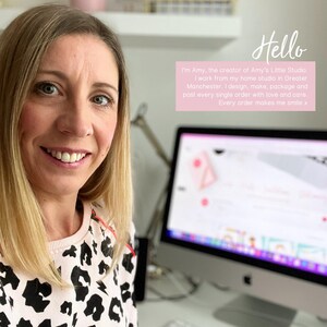 Puede incluir: Una mujer sonriente con cabello rubio lleva un su&eacute;ter rosa y negro estampado. El texto en la imagen dice "Hello" y "I'm Amy, the creator of Amy's Little Studio." Un monitor de computadora es visible en el fondo.