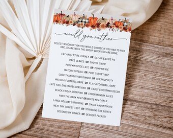 May include: A white card with a fall-themed border and the text "would you rather" in black script. The card features a list of 10 "would you rather" questions related to Thanksgiving and the holiday season.