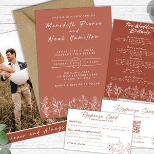 Peut inclure: Suite d'invitation de mariage rustique avec un motif floral. L'invitation présente un fond terracotta avec du texte blanc et une photo du couple. La carte des détails comprend des informations sur la cérémonie, la réception et le transport. La carte de réponse comporte un code QR et un espace pour que les invités puissent répondre.
