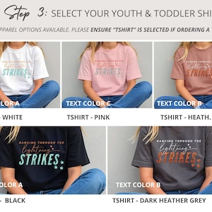 May include: A collection of five short-sleeve t-shirts in white, pink, heather mauve, black, and dark heather grey. Each shirt features the text 'DANCING THROUGH THE lightning STRIKES' with varying text colors and graphic accents like stars.