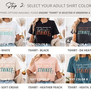 May include: A grid of six short-sleeve t-shirts in white, black, dark heather gray, soft cream, heather peach, and heather deep teal. Each shirt features the text 'DANCING THROUGH THE lightning STRIKES' with star graphics in various color combinations.