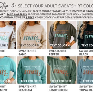 May include: A color chart for adult sweatshirts featuring eight variations in white, sand, pepper, black, chalky mint, seafoam, light green, and topaz blue. Each sweatshirt displays the text DANCING THROUGH THE LIGHTNING STRIKES in two distinct color palettes.