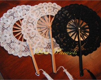 May include: Three decorative folding fans with lace trim. One fan is white, one is black, and one is white with a black lace trim. The fans have wooden handles with tassels.