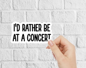 May include: White sticker with black text that reads "I'd rather be at a concert".