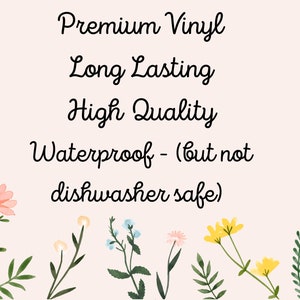 Op de afbeelding: Een roze achtergrond met zwarte tekst die "Premium Vinyl, Long Lasting, High Quality, Waterproof - (but not dishwasher safe)" luidt. De tekst wordt omringd door een rand van groene bladeren en roze, gele en blauwe bloemen.