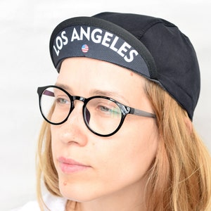 All black cycling cap. Cotton cycle hat with city state name on the brim image 1