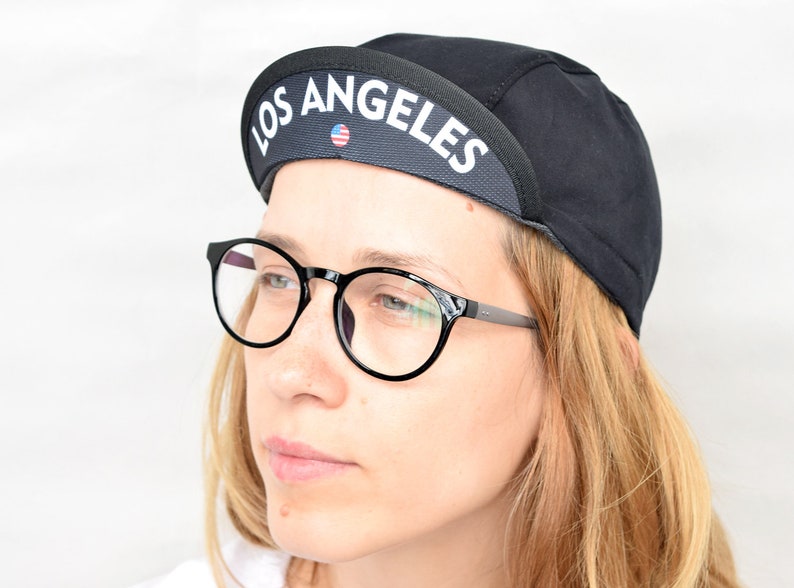 All black cycling cap. Cotton cycle hat with city state name on the brim image 1