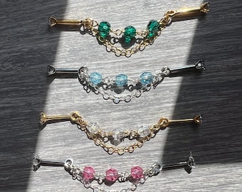 May include: Four decorative collar pins with beaded accents. The pins feature gold and silver-toned metal bars with decorative ends. Each pin has a chain with three beads in green, blue, clear, and pink.