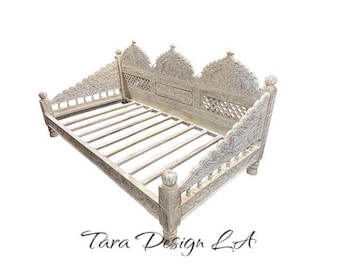 May include: White carved wooden daybed with intricate details and a slatted base. The bed is made of wood and has a white finish.