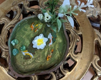 small fish pond with fish, lily pads,lillies, and 3-d plants