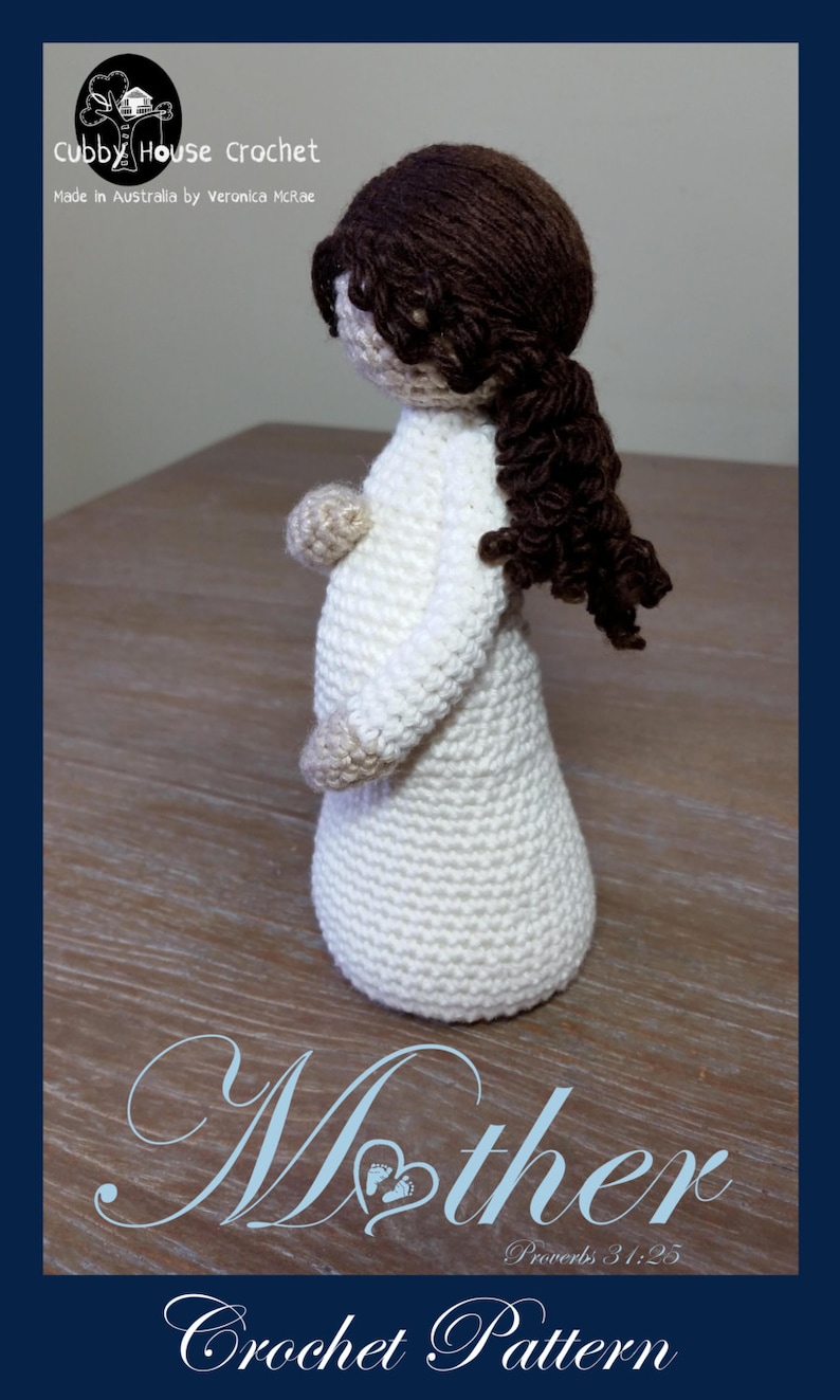 May include: Crocheted doll of a pregnant woman with brown hair, wearing a white dress. The doll is standing on a wooden surface. The text "Mother" and "Proverbs 31:25" are written below the doll. The text "Crochet Pattern" is written below the text.