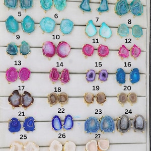 May include: Twenty-seven pairs of agate gemstone pendant charms with gold-tone jump rings. The agate is in various colors, including blue, pink, white, and brown.