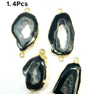 May include: Four black agate gemstone pendants with gold-toned metal loops. The agate has a white crystal pattern inside. The pendants are for jewelry making.