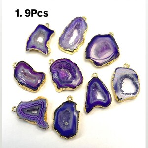 May include: Nine purple agate gemstone pendants with gold trim. Each pendant has a unique shape and pattern. The pendants are perfect for jewelry making or crafting.