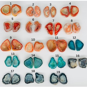 Puede incluir: Diecinueve pares de mitades de geodas de ágata, cada una con un patrón y un color únicos, incluidos el rojo, el naranja, el azul y el gris. Las geodas están dispuestas en filas de dos, numeradas del 1 al 19.