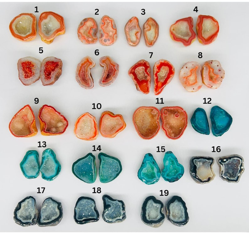 May include: Nineteen pairs of agate geode halves, each with a unique pattern and color, including red, orange, blue, and gray. The geodes are arranged in rows of two, numbered 1 through 19.