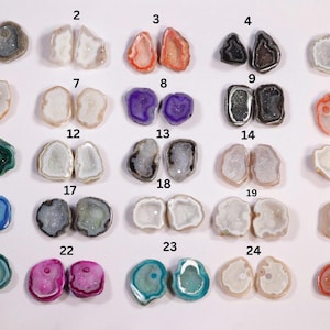 Puede incluir: Veinticinco pares de rebanadas de geoda de ágata, cada par está numerado del 1 al 25. Las rebanadas de geoda son de varios colores, incluyendo blanco, gris, rosa, azul, verde y naranja. Las rebanadas de geoda están dispuestas en cinco filas de cinco pares.