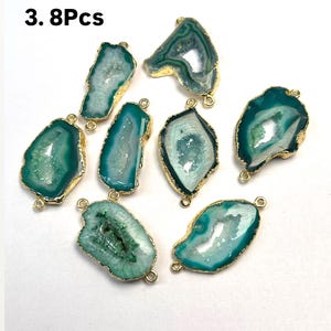 May include: Eight green agate gemstone pendants with gold-toned metal accents. The pendants are shaped like a teardrop and have a natural, organic look.