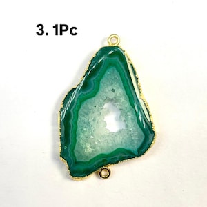 Puede incluir: Pendiente de ágata verde con un engaste de metal dorado. El ágata tiene una formación de cristal natural con un centro blanco y bordes verdes.