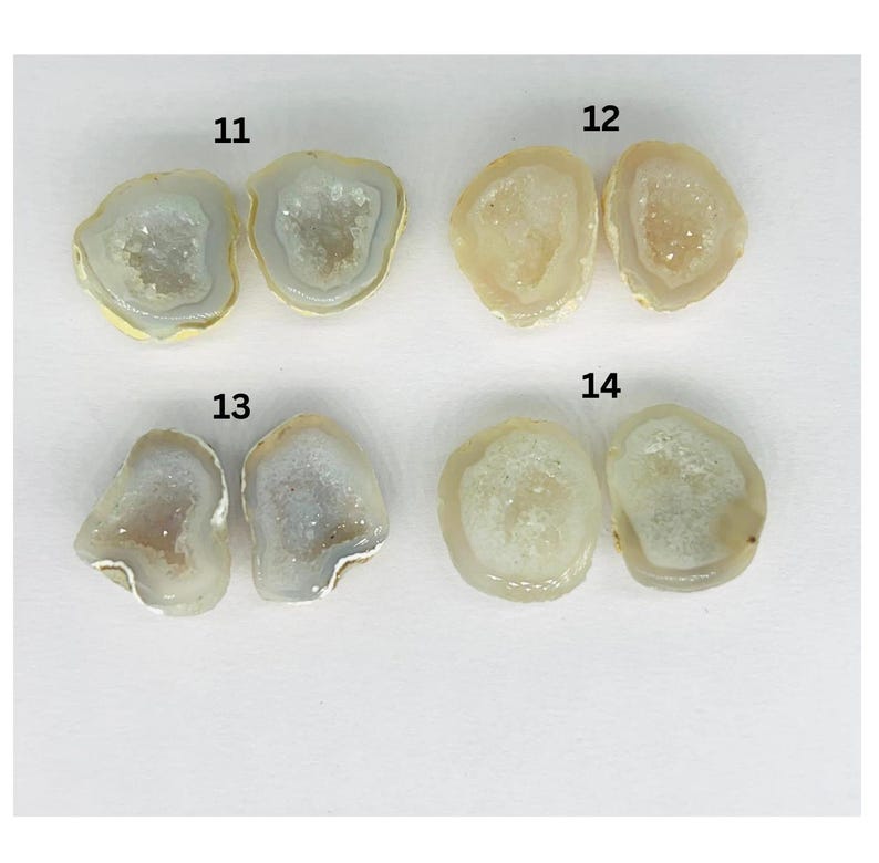 May include: Four pairs of agate geode slices, numbered 11 through 14. The geode slices are a light beige color with white crystal formations inside.