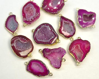 May include: Ten pink agate gemstone pendants with gold-toned metal connector loops. The agate is translucent and has a white crystalline interior.