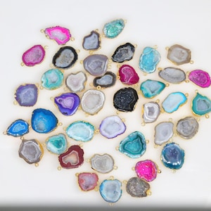 Puede incluir: Surtido de colgantes de piedra de ágata con detalles metálicos dorados. Los colgantes son de diversas formas y tamaños y presentan una variedad de colores, entre ellos rosa, azul, morado, verde y blanco.