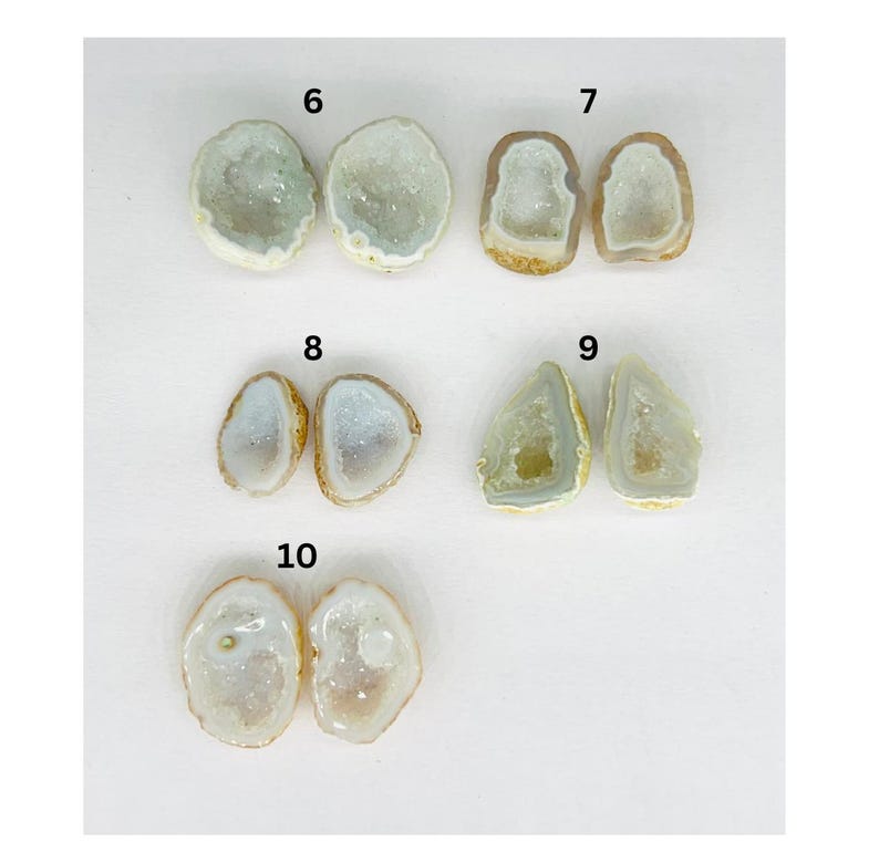 May include: Six pairs of natural crystal geodes, each pair is numbered 6 through 10. The geodes are various shapes and sizes, with a white, translucent interior and a brown exterior.