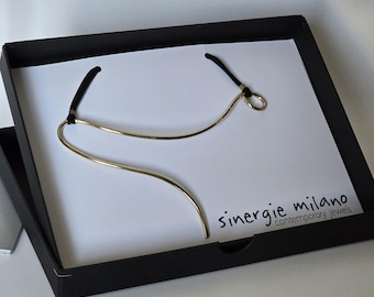 Minimal style necklace, geometric and nonconformist design. In gold plated brass.