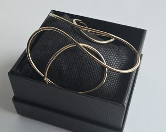 Gold-tone band bracelet. Soft lines with a bold, modern design. Bright, lightweight, original, and elegant.