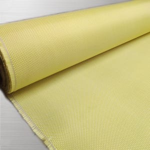 May include: A roll of yellow carbon fiber fabric. The fabric has a woven texture and is rolled up tightly.