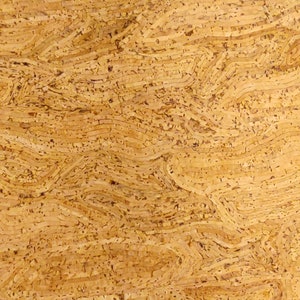 May include: Close-up of a textured, light brown surface with a layered, wavy pattern. The design resembles the natural grain of wood or cork, with variations in tone and texture creating depth and visual interest. The overall effect is organic and tactile.