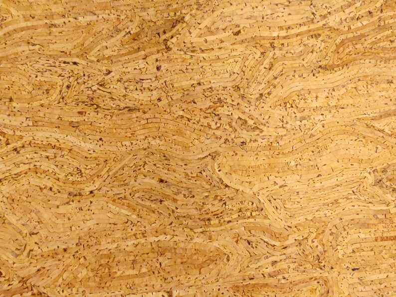 May include: Close-up of a textured, light brown surface with a layered, wavy pattern. The design resembles the natural grain of wood or cork, with variations in tone and texture creating depth and visual interest. The overall effect is organic and tactile.