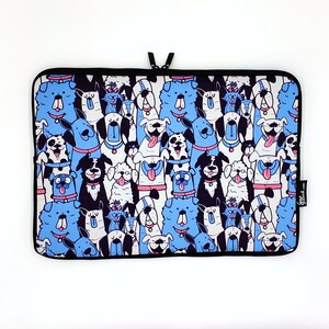 May include: A laptop sleeve with a white background and a pattern of blue, black, and white dogs. The dogs are all different breeds and have different expressions. The sleeve has a black zipper and a black border.