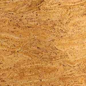 May include: Close-up of a textured, light brown cork surface. The cork has a layered, wavy pattern with small, dark brown specks throughout. The design creates a natural, organic aesthetic, suitable for various craft projects.