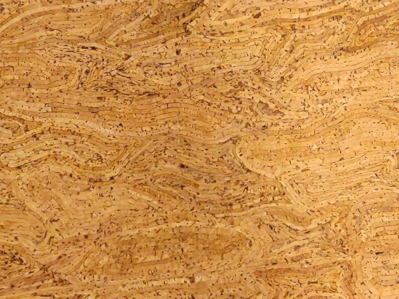 May include: Close-up of a textured, light brown cork surface. The cork has a layered, wavy pattern with small, dark brown specks throughout. The design creates a natural, organic aesthetic, suitable for various craft projects.